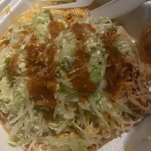 shredded chicken, lettuce, cheese, and sauce in a styrofoam container