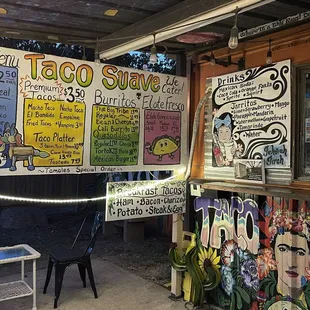 a taco stand with a variety of signs