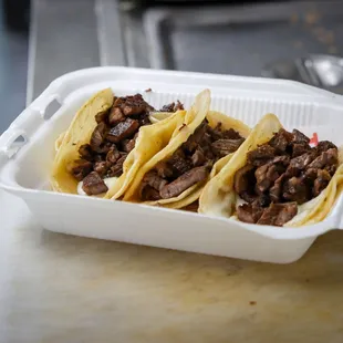 three tacos in a styrofoam container