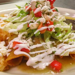 Enchiladas! Your choice of chicken or beef, topped with lettuce, pico de gallo, guacamole, sour cream, queso fresco &amp; green or red salsa.