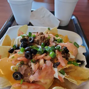 Large super nachos (comes with ground beef) hold the jalapeños, $5.99. Small strawberry shake $2.89. 3-6-2022