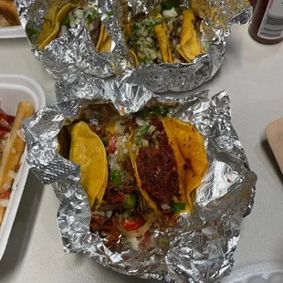 two tacos and fries on a table