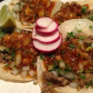 three tacos on a paper plate