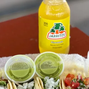 a plate of tacos and a bottle of juice
