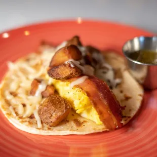 Breakfast Bacon Taco - bacon, eggs, potatoes, cheese, salsa verde on a homemade flour tortilla