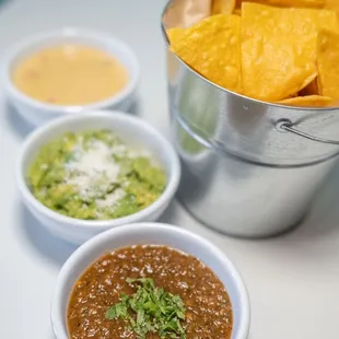 Salsa roja, guacamole and queso with chips