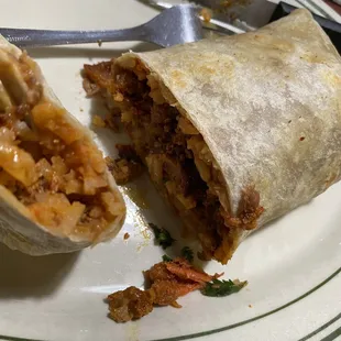 a burrito cut in half on a plate