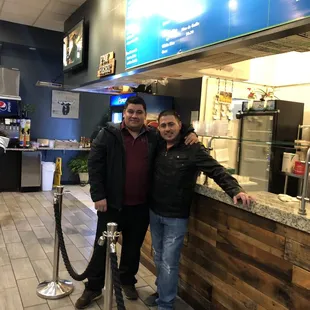 two men standing in front of a counter
