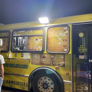 people standing in front of a taco bus