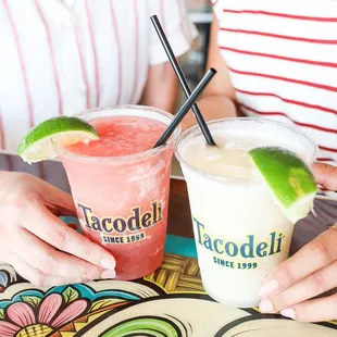 two people sitting at a table with drinks
