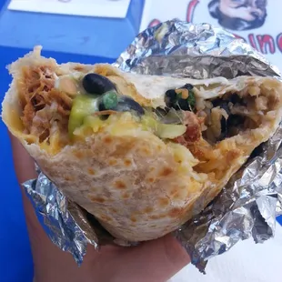 a hand holding a burrito