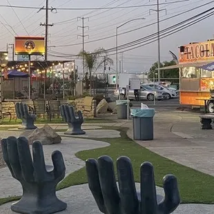 a view of a taco truck and a statue of a hand