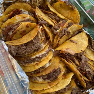 a tray full of tacos on a table