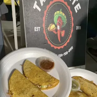 a plate of quesadillas and a sign