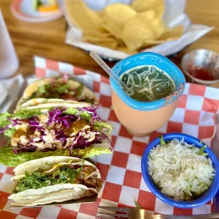 ows a plate of tacos, rice, and salsa