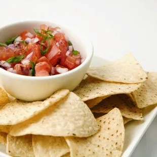 a bowl of salsa and tortillas