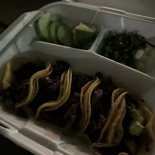 three tacos in a styrofoam container