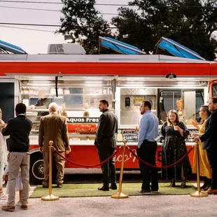 a line of people waiting to order food from a food truck