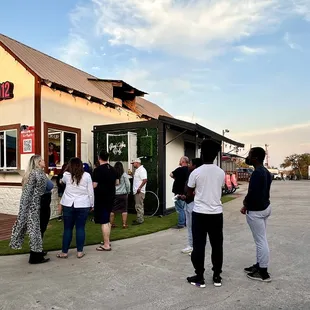 a group of people standing outside a restaurant