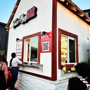 people standing outside of a restaurant