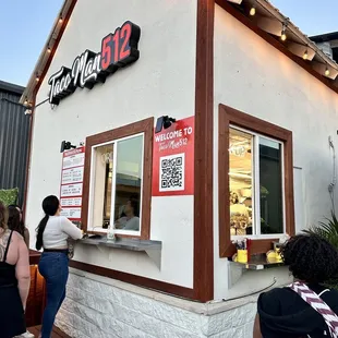 people standing outside of a restaurant