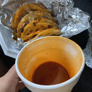 a person holding a cup of hot sauce