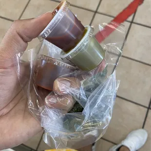 a person holding a bag of condiments