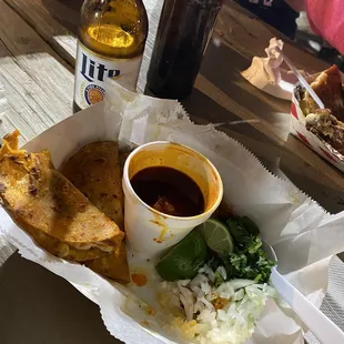 a basket of food and a bottle of beer