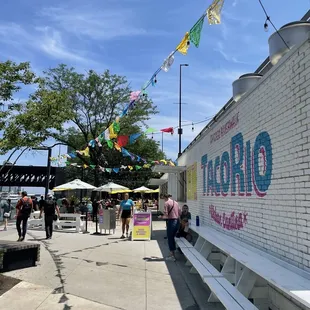people walking by a taco truck
