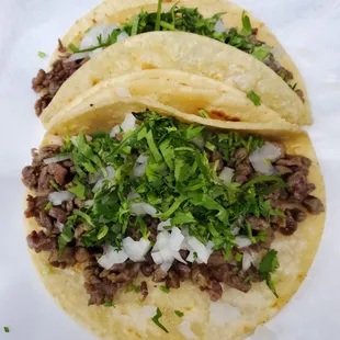 two ground beef tacos on a paper plate