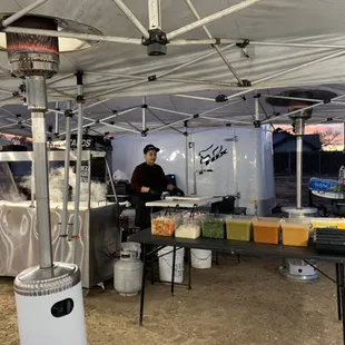 a man preparing food under a tent