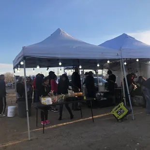 a group of people standing under a tent
