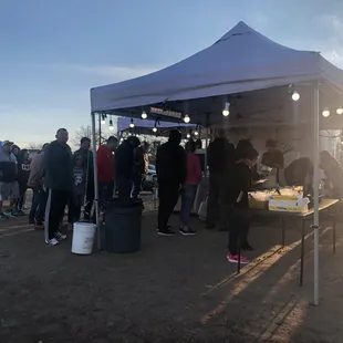 a group of people standing under a tent