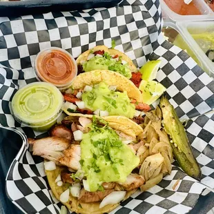 two plates of tacos and a pickle