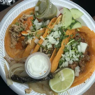 (Left to right) two chicken tacos then al pastor taco with onions and cilantro. It comes with a red salsa (not pictured) and green.