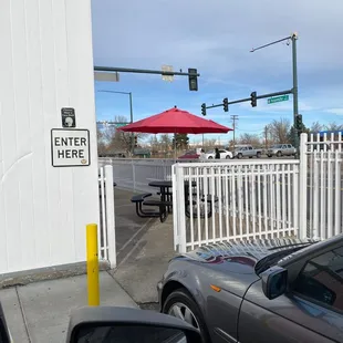 a parking lot with tables and umbrellas