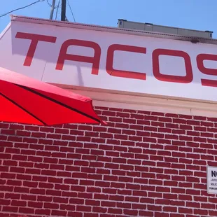 a taco&apos;s sign on a brick building