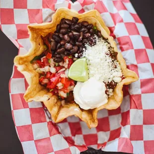 Fried Flour tortilla served with lettuce, black beans, fresh guacamole, fresh cheese, Pico de gallo, sour cream, with any meat