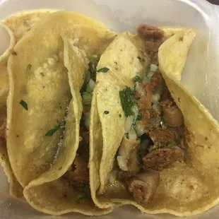 two tacoss in a styrofoam container