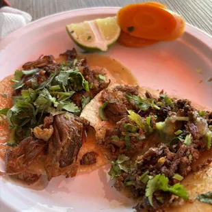 Carnitas and asada tacos (with a bite missing)