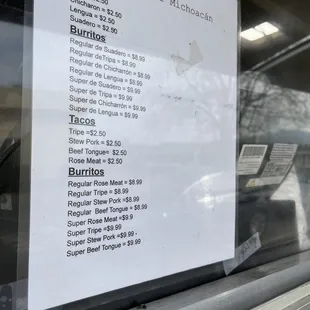 Paper menu on window which shows higher prices than what is on the truck