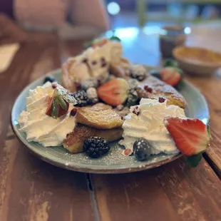 Churro French toast con Strawberries, Blueberries, and Whip Cream.