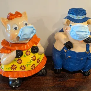 two figurines wearing masks