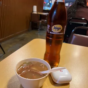 a cup of soup and a bottle of bud