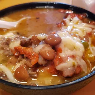 Frijoles Preparados - Charro Beans with onion, tomato, pastor pork meat, bistec meat, and covered in white cheese