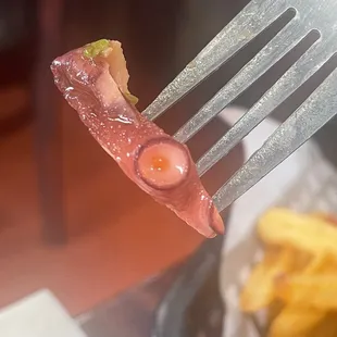 ows a piece of bacon on a fork