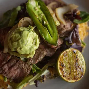 Carne Asada Chef Specialty: Enjoy tender steak, rice, grilled onions, guacamole, jalapeño, and tortillas for a savory, flavorful dish.