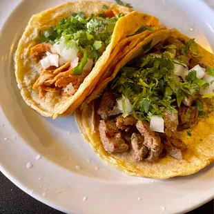 Steak and chicken tacos with cilantro and onion the water is from my limes I splashed on top of the tacos