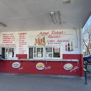 a man standing in front of a taco stand