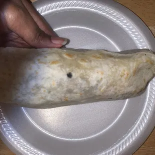 a hand holding a burrito